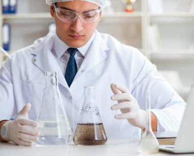 Genç araştırmacı bilim adamı bir su testi kirliliği araştırması yapıyor.