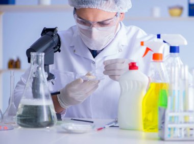 Laboratuvardaki adam yeni temizlik çözeltisi deterjanı test ediyor.