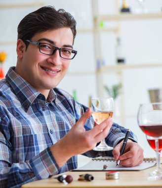 Profesyonel şarap garsonu kırmızı şarap tadıyor.