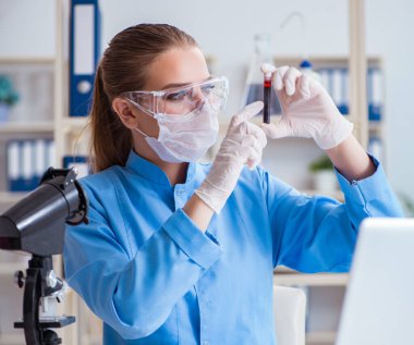 Bir laboratuarda deney yapan kadın bir bilim adamı.