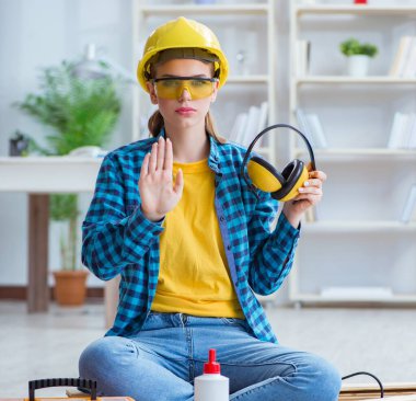 Tamirci kadın marangoz ahşap döşemeleri kesiyor.