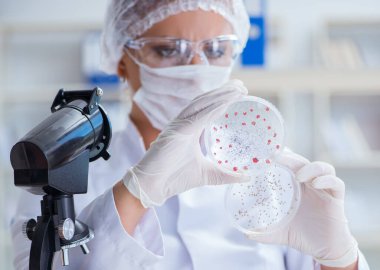 Bir laboratuarda deney yapan kadın bir bilim adamı.