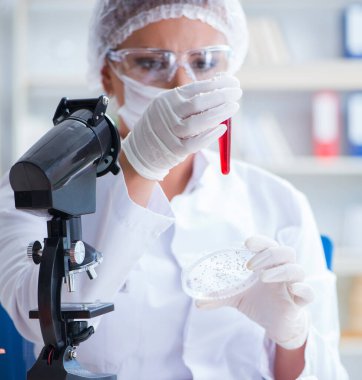 Bir laboratuarda deney yapan kadın bir bilim adamı.