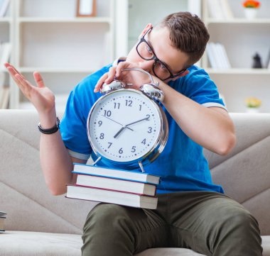 Sınavlara hazırlanan genç öğrenci kanepede ders çalışıyor.