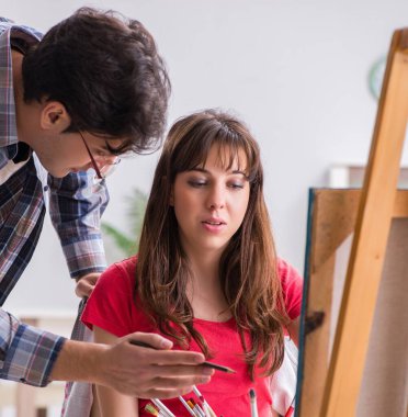 Stüdyoda resim sınıfında sanatçı koçluğu yapan bir öğrenci.