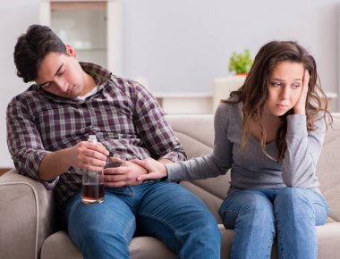 Genç bir aile kavramında içki sorunu yaşayan sarhoş bir koca.