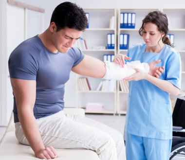 Hastanede yaralanma kontrolü sırasında doktor ve hasta.