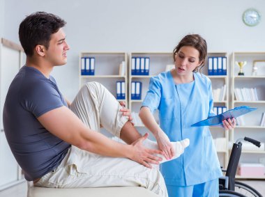 Hastanede yaralanma kontrolü sırasında doktor ve hasta.