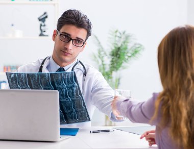 Doktor hastanın röntgen görüntülerini inceliyor.