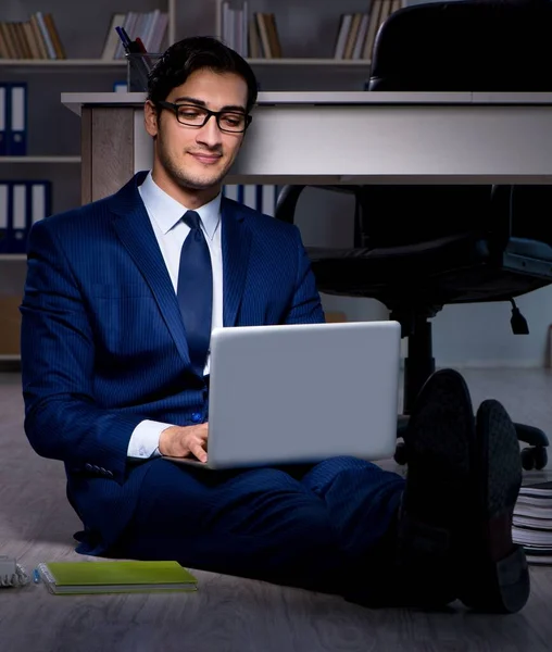 Businessman working overtime long hours late in office