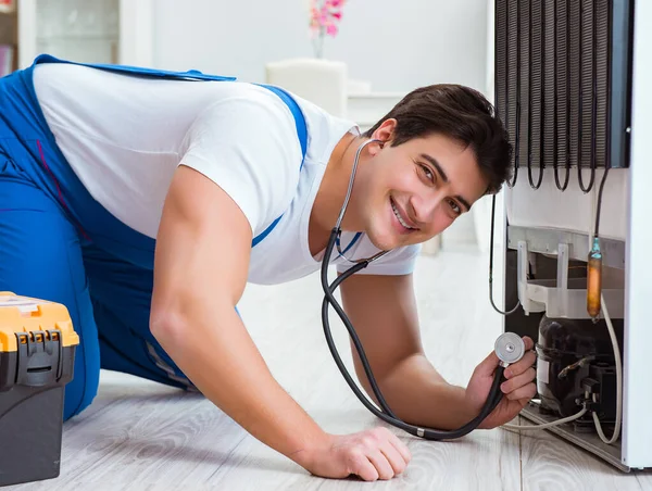 Repairman contractor repairing fridge in DIY concept