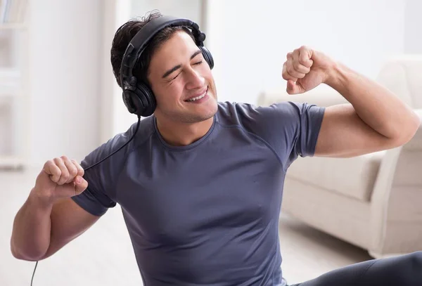 Man die thuis sport doet en naar muziek luistert — Stockfoto