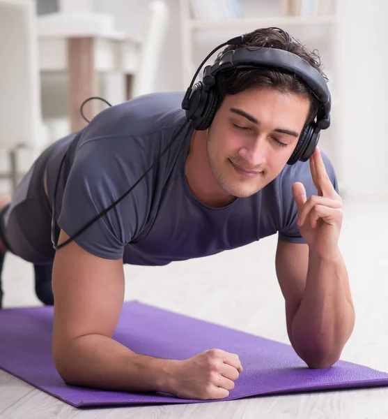 Man melakukan olahraga di rumah dan mendengarkan musik — Stok Foto