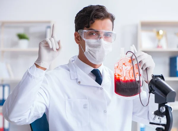 Médico trabajando con muestras de sangre en el laboratorio de la clínica hospitalaria —  Fotos de Stock