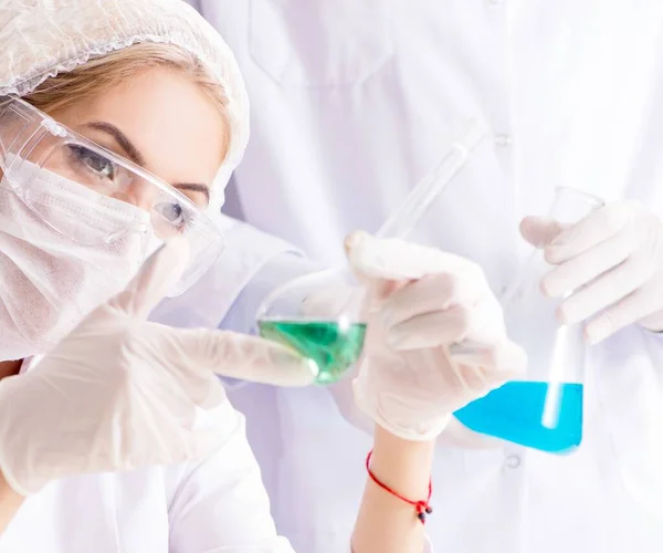 Mujer joven química que trabaja en el laboratorio de la clínica —  Fotos de Stock