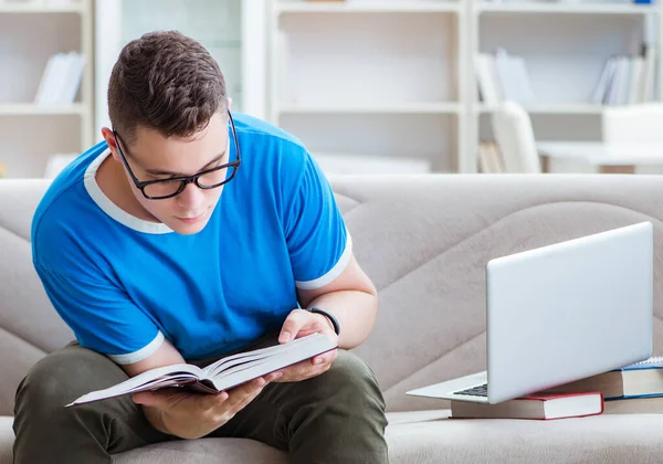 若い学生はソファの上で自宅で勉強するための試験の準備 — ストック写真