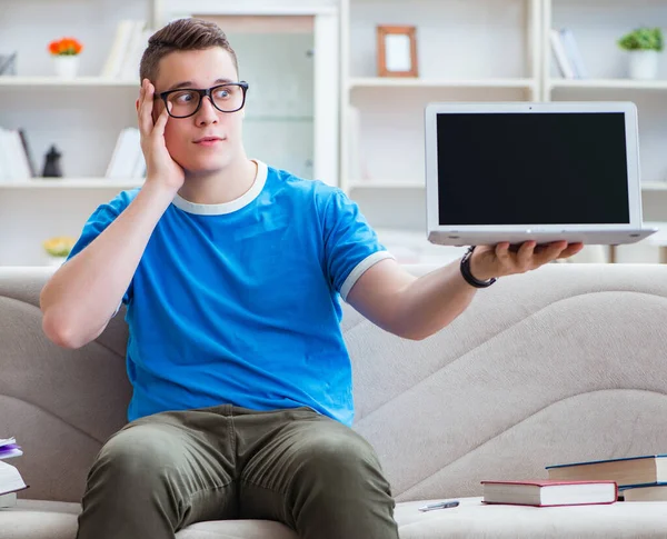 Estudiante joven preparándose para los exámenes que estudian en casa en un sofá —  Fotos de Stock