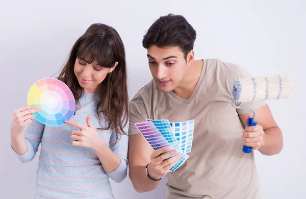 Jovem família fazendo renovação em casa - paredes de pintura — Fotografia de Stock