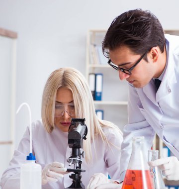 Laboratuvarda tartışan iki kimyager.