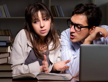 İki öğrenci geç saatlere kadar çalışıp sınavlara hazırlanıyor.