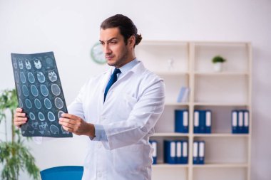 Klinikte çalışan yakışıklı genç bir doktor.