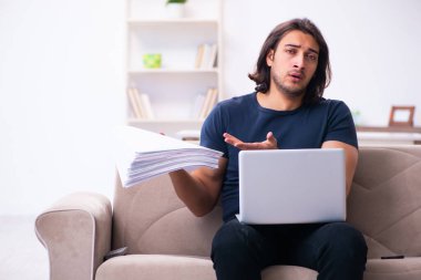 Evden çalışan genç bir adam.