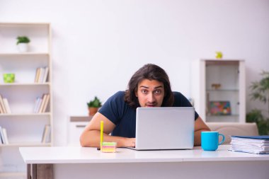 Evden çalışan genç bir adam.