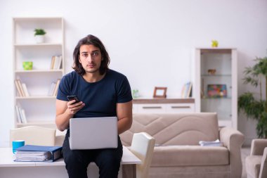 Evden çalışan genç bir adam.