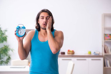 Genç adam evde uyanıyor.