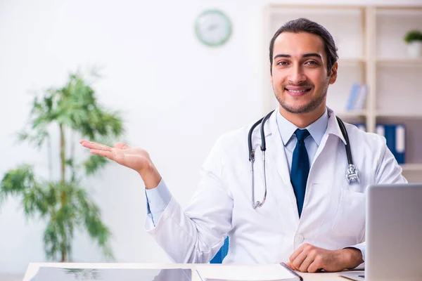 Jonge mannelijke knappe arts werkzaam in de kliniek — Stockfoto