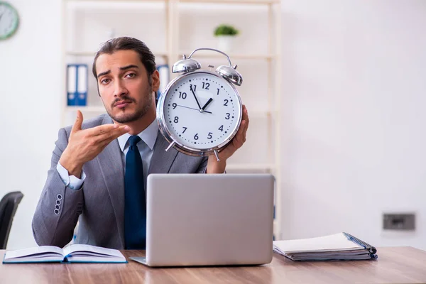 Jonge mannelijke zakenman die boeken leest op het werk — Stockfoto