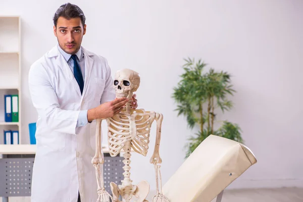 Jovem médico masculino com esqueleto — Fotografia de Stock