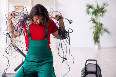 İçeride çalışan komik genç elektrikçi.