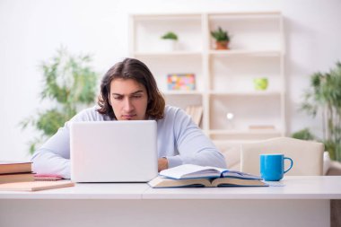 Evde sınava hazırlanan genç bir erkek öğrenci.