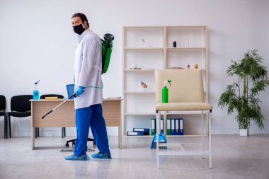 Genç erkek müteahhit salgın konseptinde dezenfekte kliniği