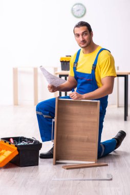 Genç erkek marangoz içeride çalışıyor.