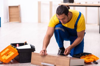 Genç erkek marangoz içeride çalışıyor.