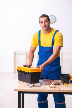 Genç erkek marangoz içeride çalışıyor.