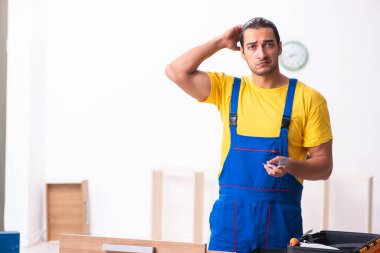 Genç erkek marangoz içeride çalışıyor.