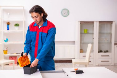 Genç erkek marangoz içeride çalışıyor.