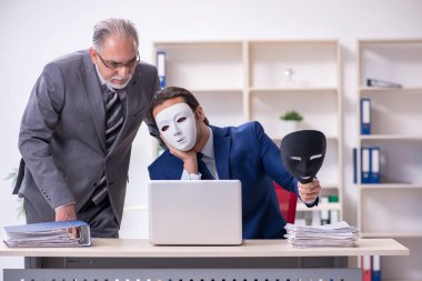 Eski patron ve genç erkek çalışan maske takıyor.