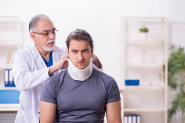 Genç yaralı boksör yaşlı doktor travmatoloğu ziyaret ediyor.