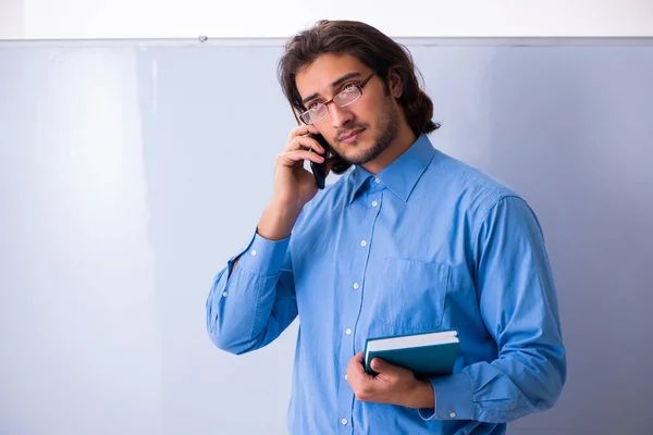 Young male teacher in the classroom — Stock Photo, Image