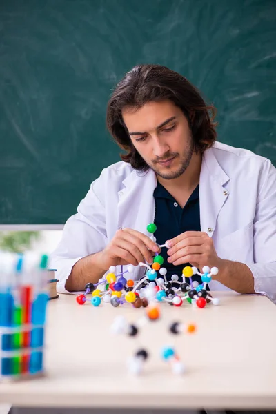 Fiatal férfi tudós ül az osztályteremben — Stock Fotó