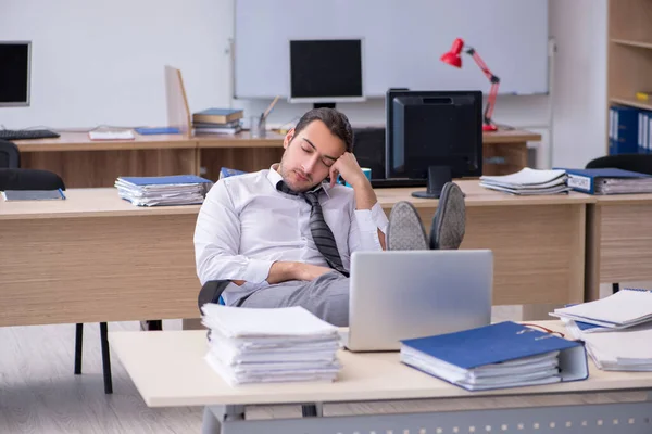 Joven empleado masculino infeliz con el trabajo excesivo —  Fotos de Stock