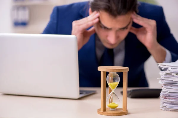 Jonge mannelijke werknemer in tijdmanagementconcept — Stockfoto