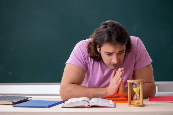 Junge männliche Schüler im Klassenzimmer bei Zeitmanagement-Konzept — Stockfoto