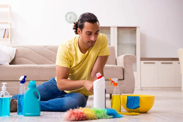 Jonge mannelijke aannemer doet huishoudelijk werk thuis — Stockfoto