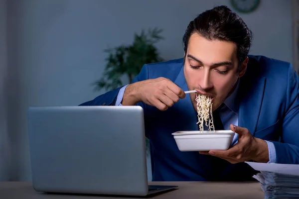 Funcionário com fome trabalhando até tarde no escritório — Fotografia de Stock