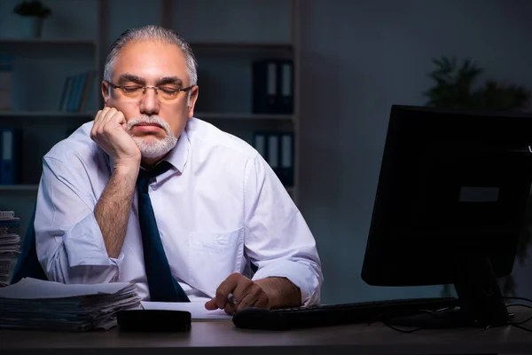 Velho empregado do sexo masculino trabalhando até tarde no escritório — Fotografia de Stock